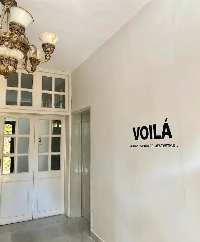 Voila Luxury Skincare Aesthetics signage and elegant chandelier at the clinic entrance